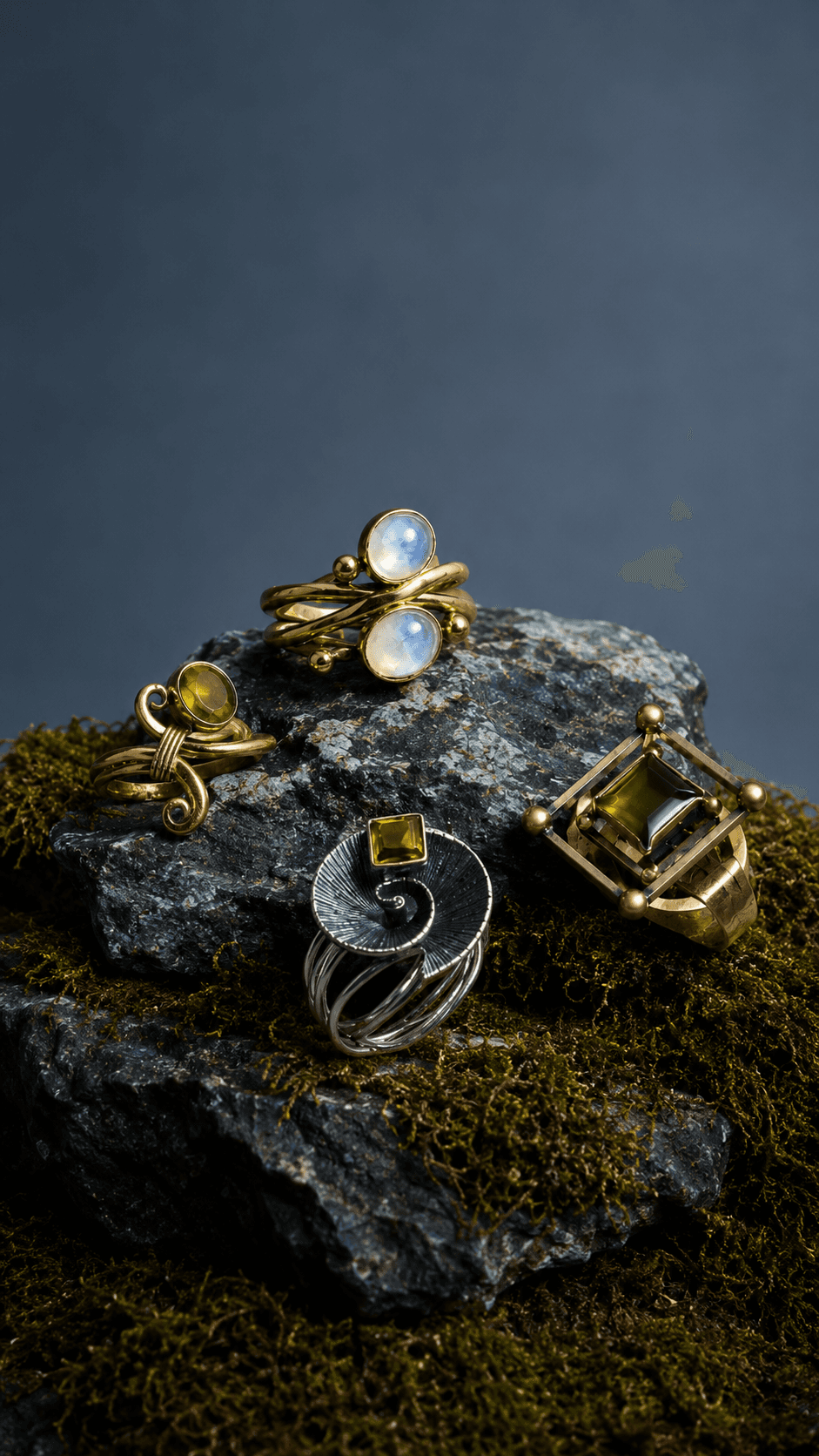 Sapheen artisan rings in silver and gold with green gemstones on moss and stone
